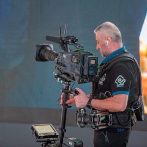 Camarógrafo profesional que captura imágenes de alta calidad para fotografía de prensa y medios.